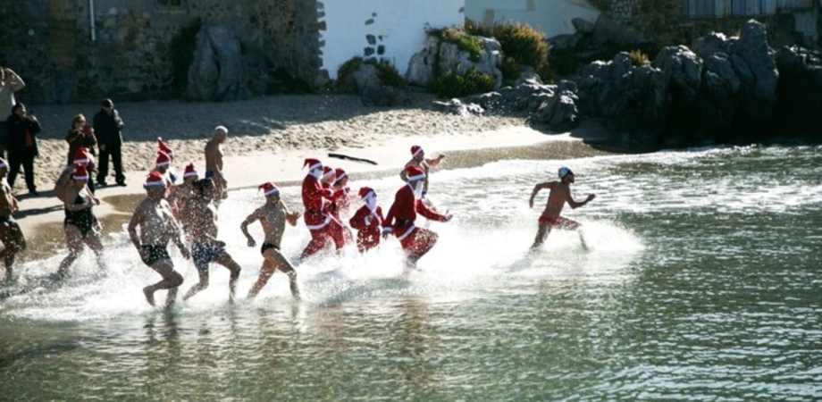 Bagno in mare a Cefalù con cappellini e vestiti da Babbo Natale